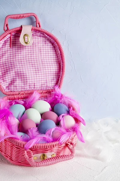 快乐的复活节-粉红色篮子充满彩色鸡蛋和羽毛上 — 图库照片