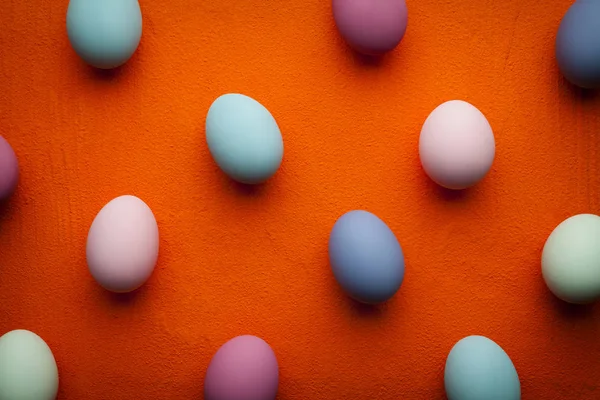 Påsk bakgrund - färgade ägg på orange tabell — Stockfoto