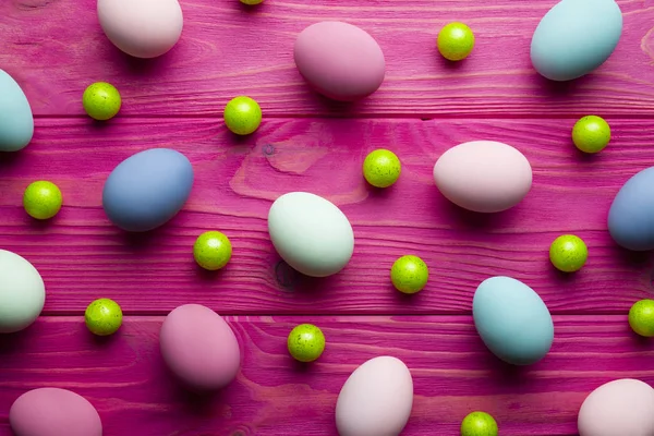 Gekleurde paaseieren en groene ballen op roze houten achtergrond — Stockfoto