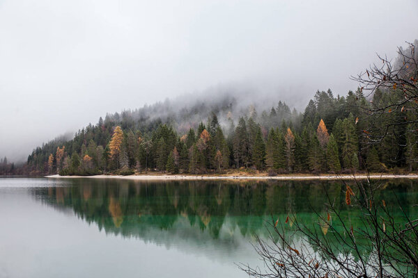 alpine lake in foggy morning in mountains
