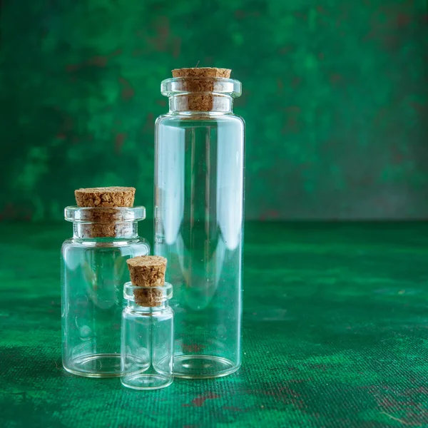 empty glass test-tubes with bungs at green background