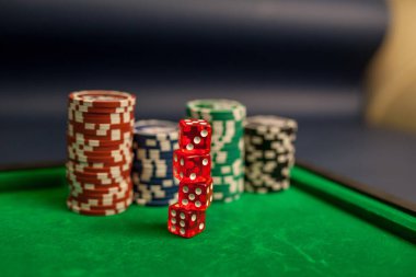 Yeşil poker masasında iskambil kağıtları, zarlar ve poker fişleri