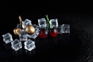 Siyah zemin üzerinde buzun içinde donmuş altın kiraz