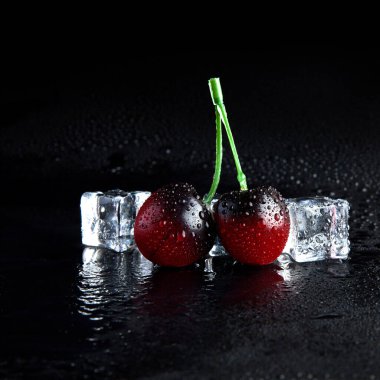 Siyah zemin üzerinde buzun içinde donmuş kiraz