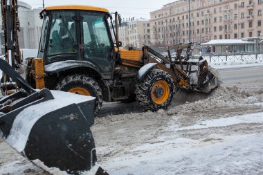 Parkta kar temizleyen traktör.