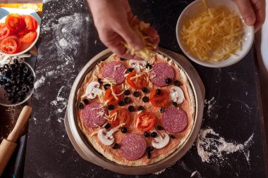 Yemek konsepti. Taze, orijinal İtalyan çiğ pizzası, geleneksel tarzda hazırlanma. Evde pizza yapmak. Gerçek bir evde pizza pişirmek.