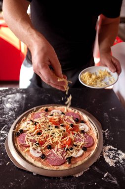 Yemek konsepti. Taze, orijinal İtalyan çiğ pizzası, geleneksel tarzda hazırlanma. Evde pizza yapmak. Gerçek bir evde pizza pişirmek.