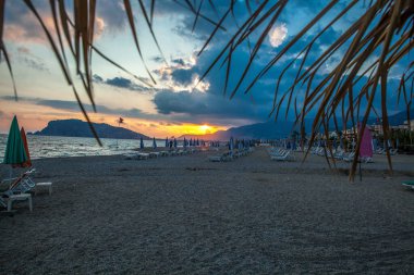 İnanılmaz sahil gün batımı ve inanılmaz köpüklü dalgalar. Arkaplanda tepe.