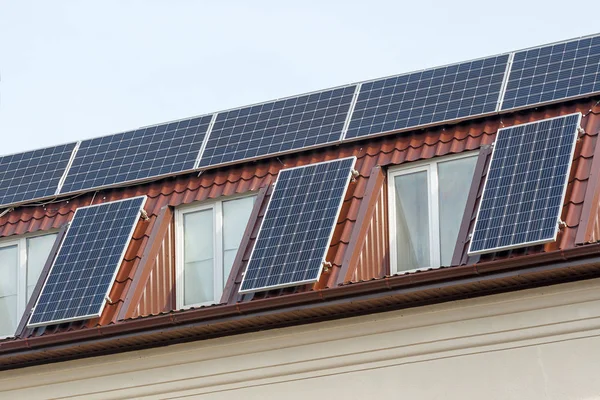 Paneles solares para la energía verde en el techo de baldosas de la casa Fotos de stock libres de derechos