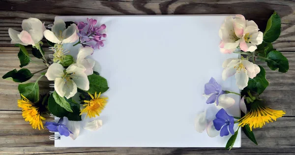Tom sida av en anteckningsbok och våren blommor — Stockfoto