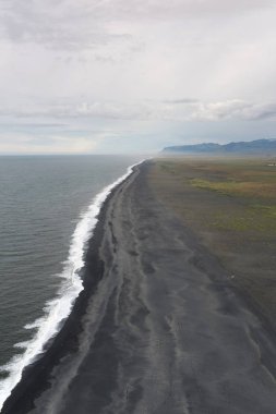 Tipik İzlanda dağ manzaraları ile siyah kum plaj 