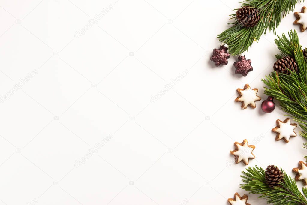 Christmas composition. Spruce branches with cones and christmas cookies, on a white background. Christmas, winter concept. Flat lay, top view, copy space.