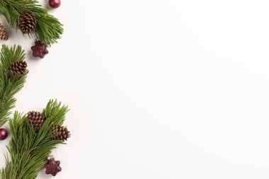 Noel kompozisyonu. Beyaz arka planda koni ve noel süslemeleri olan ladin dalları. Noel, kış, yeni yıl konsepti. Düz konum, üst görünüm, kopyalama alanı.