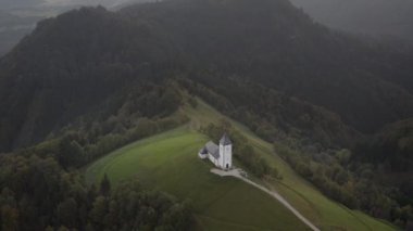Slovenya 'da bir tepenin üstündeki güzel bir kilisenin sonbahar hava manzarası