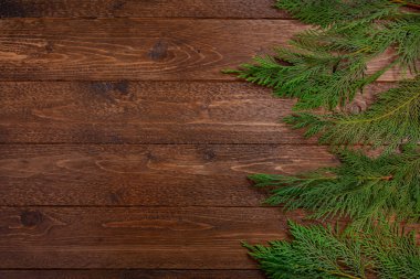 Minimum Noel kompozisyonu. Koyu ahşap arka planda selvi dalları. Noel, kış konsepti. Düz yatış, üst görünüm.