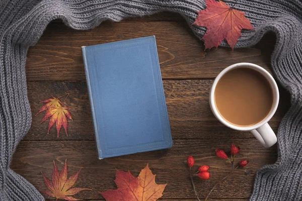 Dekorasyon unsurları, kitap ve akçaağaç yaprakları ile sonbahar temalı koyu ahşap masa. Yaratıcı Düz Düzlem ve Üst Görünüm bileşimi 