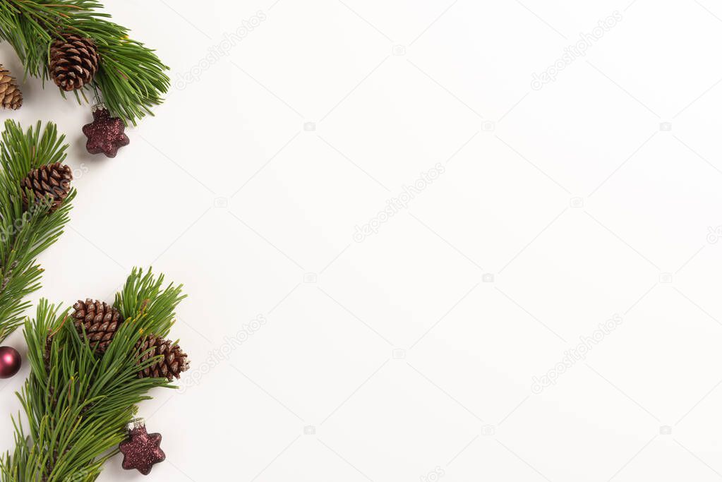Christmas composition. Spruce branches with cones and christmas decorations, on a white background. Christmas, winter, new year concept. Flat lay, top view, copy space.