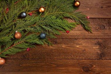 Noel ya da Yeni Yıl dekorasyon geçmişi. Toplarla süslenmiş ladin dalı, koyu ahşap arka planda. Düz konum, üst görünüm, kopyalama alanı.