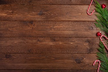 Minimum Noel kompozisyonu. Koyu ahşap arka planda selvi dalları ve şeker kamışı. Noel, kış konsepti. Düz yatış, üst görünüm.