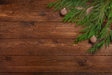 Minimum Noel kompozisyonu. Koyu ahşap arka planda, kristal kürelere uzanan selvi dalları. Noel, kış konsepti. Düz yatış, üst görünüm.