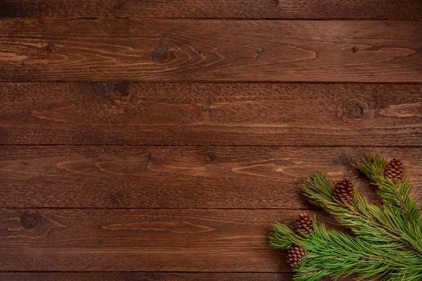 最小的圣诞作文 长有圆锥的云杉分枝 深色的木制背景 圣诞节 冬天的概念 平躺在地上 俯瞰四周 — 图库照片
