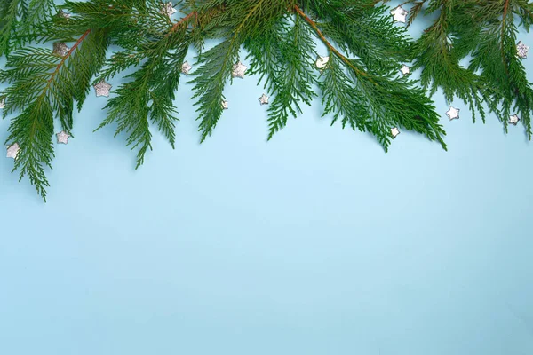 喜庆的圣诞背景与杉树枝条 平面布局 浅蓝色背景的顶部视图 带有复制空间 — 图库照片