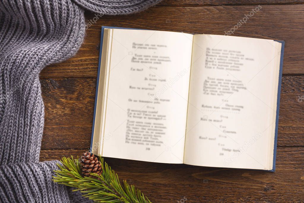 Open book and winter decor, on wooden background. Flat lay, top view, copy space.