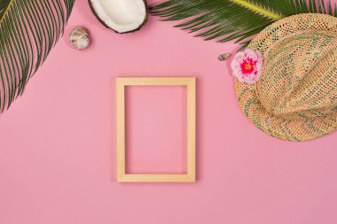 Composition with beach accessories and photo frame, on pink background. Top view, copy space. Flat lay.
