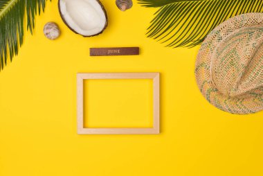 Composition with beach accessories and photo frame, on yellow background. Top view, copy space. Flat lay.