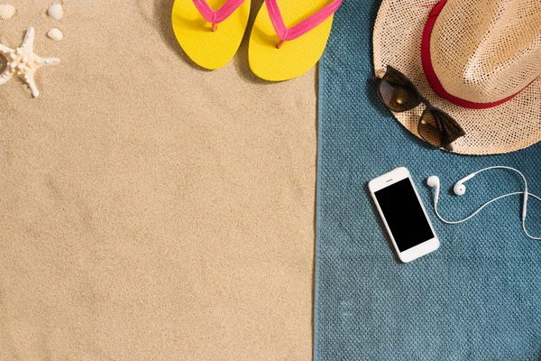 夏休みの構成 砂の背景に帽子 スマートフォン サングラス 影の強い光 夏の背景 タオル製のボーダー構成 — ストック写真
