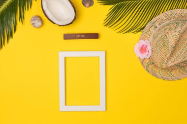 Composition with beach accessories and photo frame, on yellow background. Top view, copy space. Flat lay.