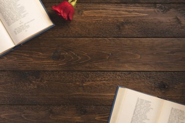 Romantik bir kavram. Ahşap arka planda, üzerinde şiirler ve güller olan kitapları aç. Düz konum, üst görünüm, kopyalama alanı.