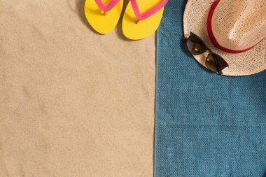 Yaz tatili kompozisyonu. Şapka, güneş kremi ve güneş gözlüğü. Gölgeli sert bir ışık. Yaz dönemi. Havludan yapılmış kenar bileşimi