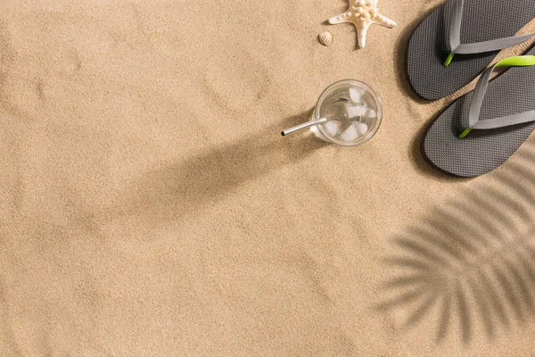タオルフレームと夏のアクセサリーと砂浜のトップビュー コピースペースと目に見える砂のテクスチャの背景 影の強い光 — ストック写真