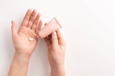 Kadın ellerine krem sürüyor. Kadın eli, kozmetik krem, beyaz arka planda izole edilmiş. Düz konum, üst görünüm, kopyalama alanı.