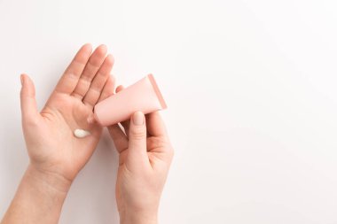 Kadın ellerine krem sürüyor. Kadın eli, kozmetik krem, beyaz arka planda izole edilmiş. Düz konum, üst görünüm, kopyalama alanı.