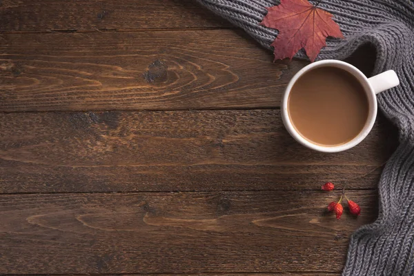 Örgü eşarplı düz bir kompozisyon, ahşap masa üzerinde bir fincan kahve. Hygge tarzı, sıcak sonbahar ya da kış tatili konsepti. Düz yatıyordu, üstten, yukarıdan..