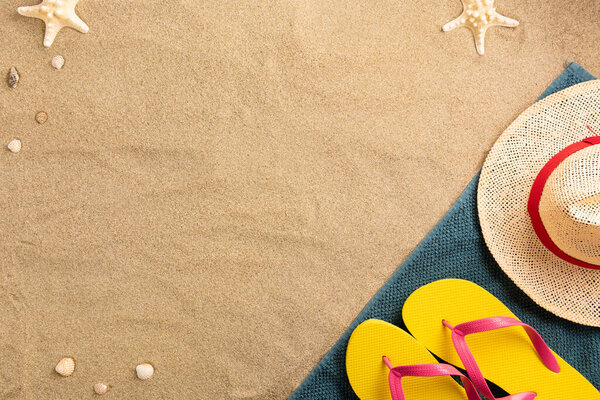 Beautiful summer holiday beach background with some accessories and shells on sand background, border design, top view with copy space