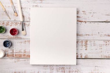 Çizimler ve boyalar için boş tuval, beyaz ahşap masa üzerine boyanmış boya fırçaları, üst görünüm, fotokopi alanı, düz yatak stili, sınıf eğitimi