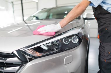 Araba ayrıntılı - adam mikrofiber elinde tutan ve araba parlatır. Seçici odak.