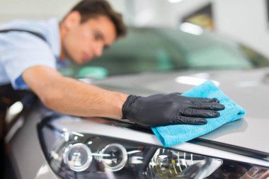 Araba ayrıntılı - adam mikrofiber elinde tutan ve araba parlatır. Seçici odak.