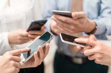 Telefon elinde tutan genç hipsters grubudur. Arkadaşlar akıllı telefonlar ile birlikte eğleniyor.