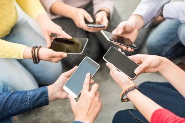 Telefon elinde tutan genç hipsters grubudur. Arkadaşlar akıllı telefonlar ile birlikte eğleniyor.