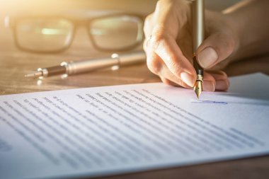 Business woman signing contract document on office desk, making a deal.
