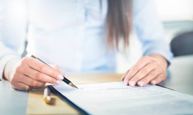 Business woman signing contract document on office desk, making a deal.