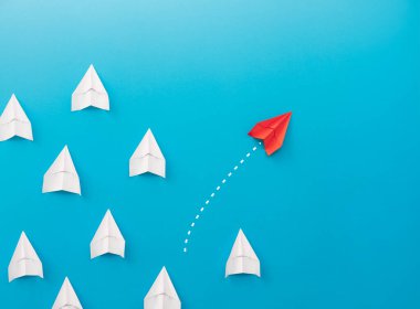 Yeni fikirler yaratıcılık ve farklı yenilikçi çözümler. İş konsepti. Bir grup kağıttan uçak, bir uçak diğer yönde uçuyor, farklı yönde..