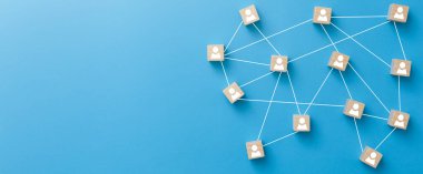 Ahşap bloklar mavi arka planda birbirine bağlanmış. Takım çalışması, ağ ve topluluk kavramı.