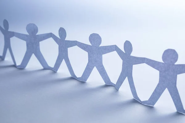 Team of paper chain people. Human chain with light and shadow. Blue tone background.