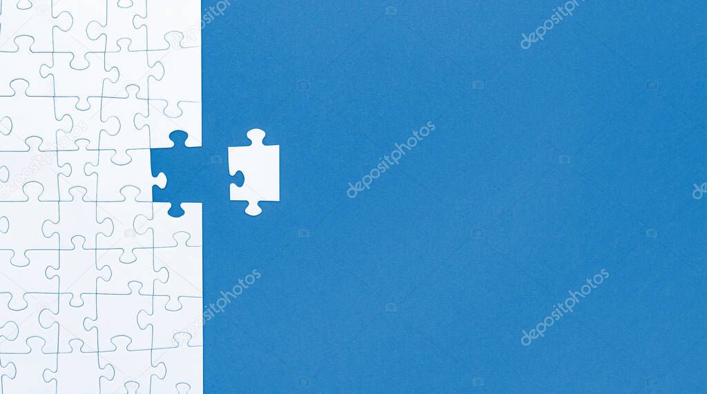 White jigsaw puzzle pieces on blue background copy space for your text. Business concept. 