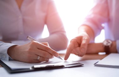 Business people negotiating a contract. Human hands working with documents at desk and signing contract.